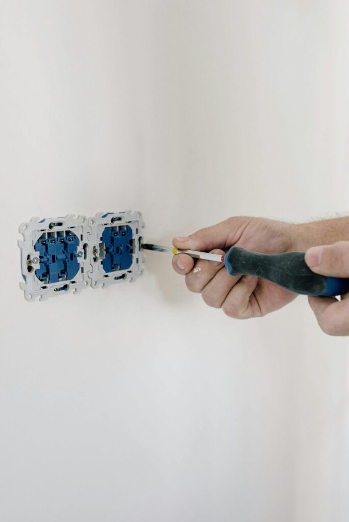elektriker-website-kitzingen Elektriker prüft Steckdose oder installiert Smart-Home-Technik. Betont Elektroinstallationen in Kitzingen.